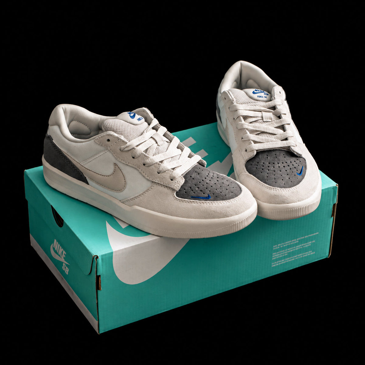 Dunk Low en crema y gris con detalles azules