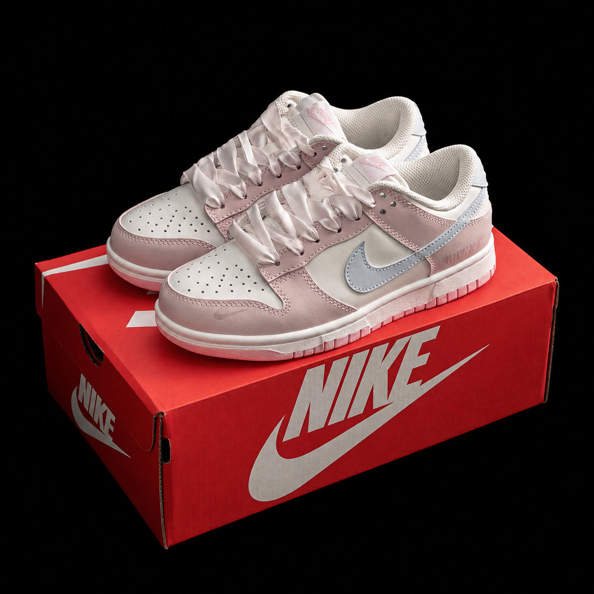 Dunk Low en rosa pastel y blanco con cordones satinados