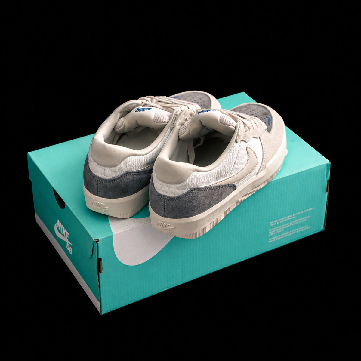 Dunk Low en crema y gris con detalles azules