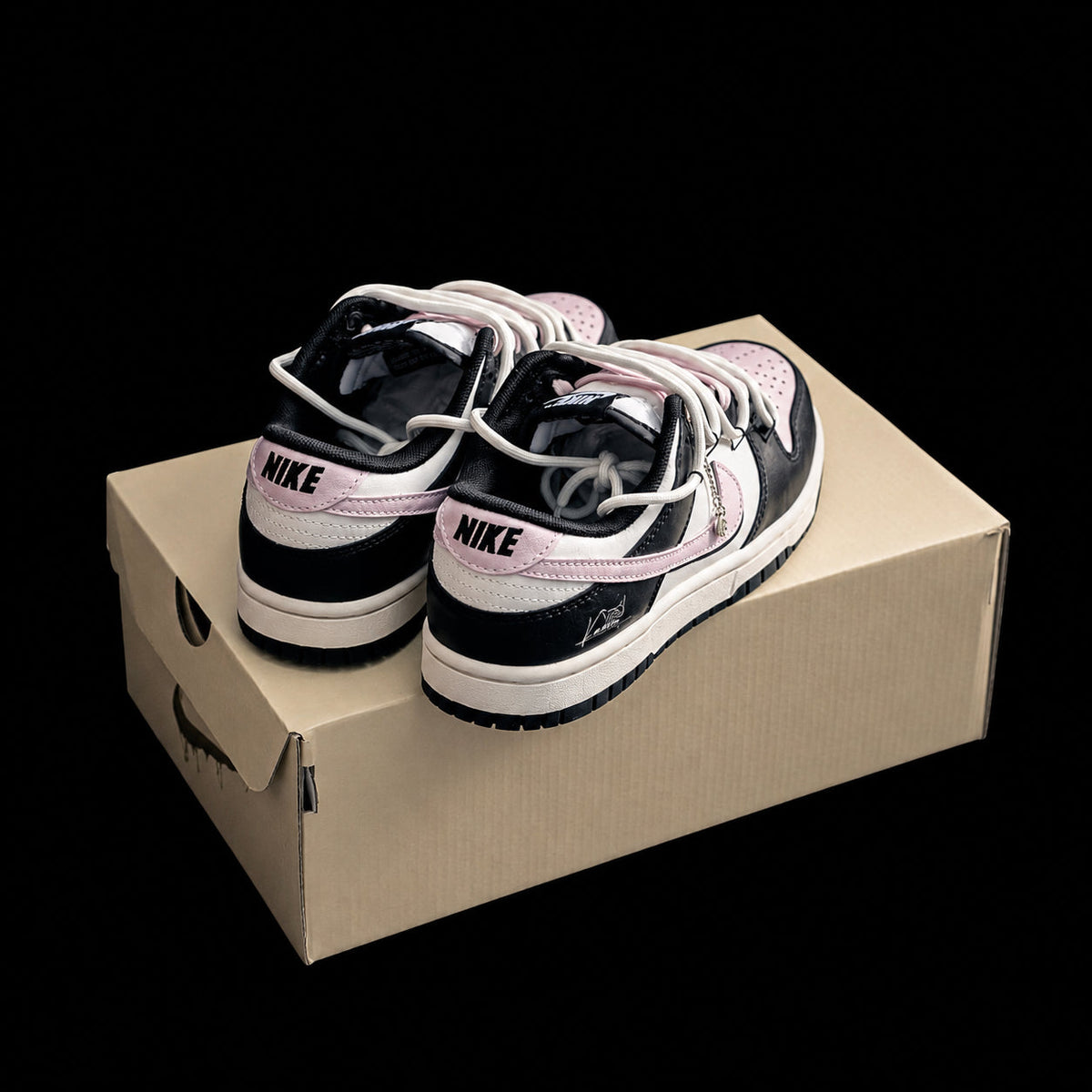 Dunk Low en negro, rosa y crema con doble cordonera